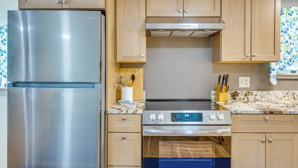 A kitchen with wooden cabinets, a stainless steel refrigerator, a built-in oven, and a microwave. - Ashland Home w/ Deck - Blueberry Overlook (Ashland)