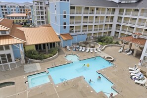 Ein Hotel mit zentralem Poolbereich, mehreren Balkonen und Außenbereich zum Sitzen.