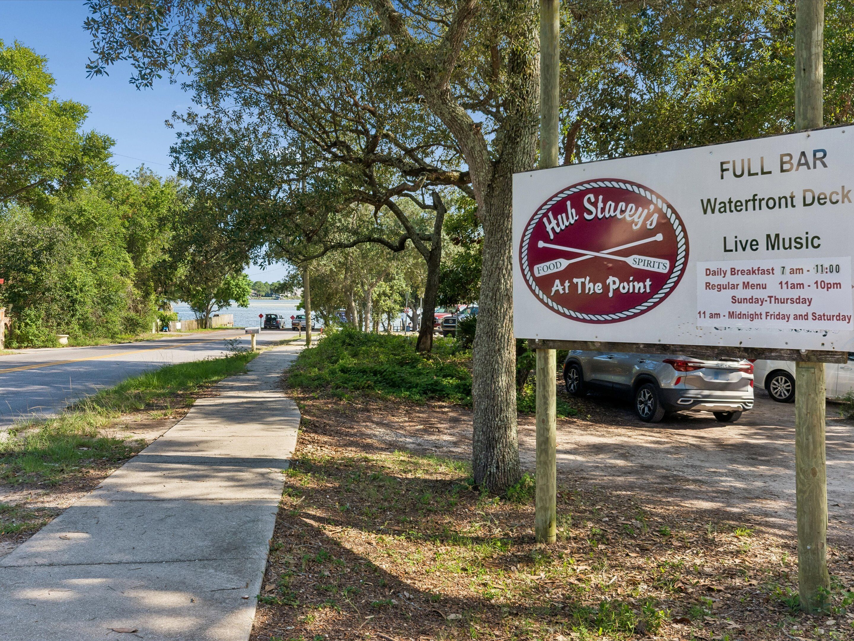 A sign for 'Hut Stages' with a full bar, waterfront deck, and live music.