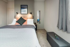 A bedroom with a bed, a bedside table, a mirror, and a window with curtains. - #38 Stylish Apart. 2|sleeps 4|5mins TamworthCastle (Staffordshire)