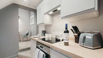 A modern kitchen with a built-in stove, a wine bottle, and a toaster.