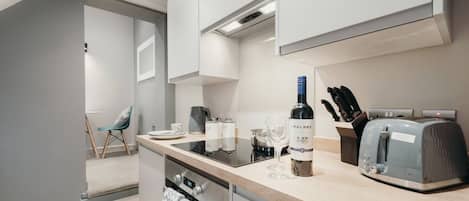 A modern kitchen with a built-in stove, a wine bottle, and a toaster.
