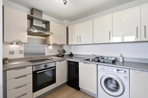 A modern kitchen with stainless steel appliances, a dishwasher, and a built-in washing machine. - #191 Mason Way Executive Stay - Sleeps 6 (West Midlands)