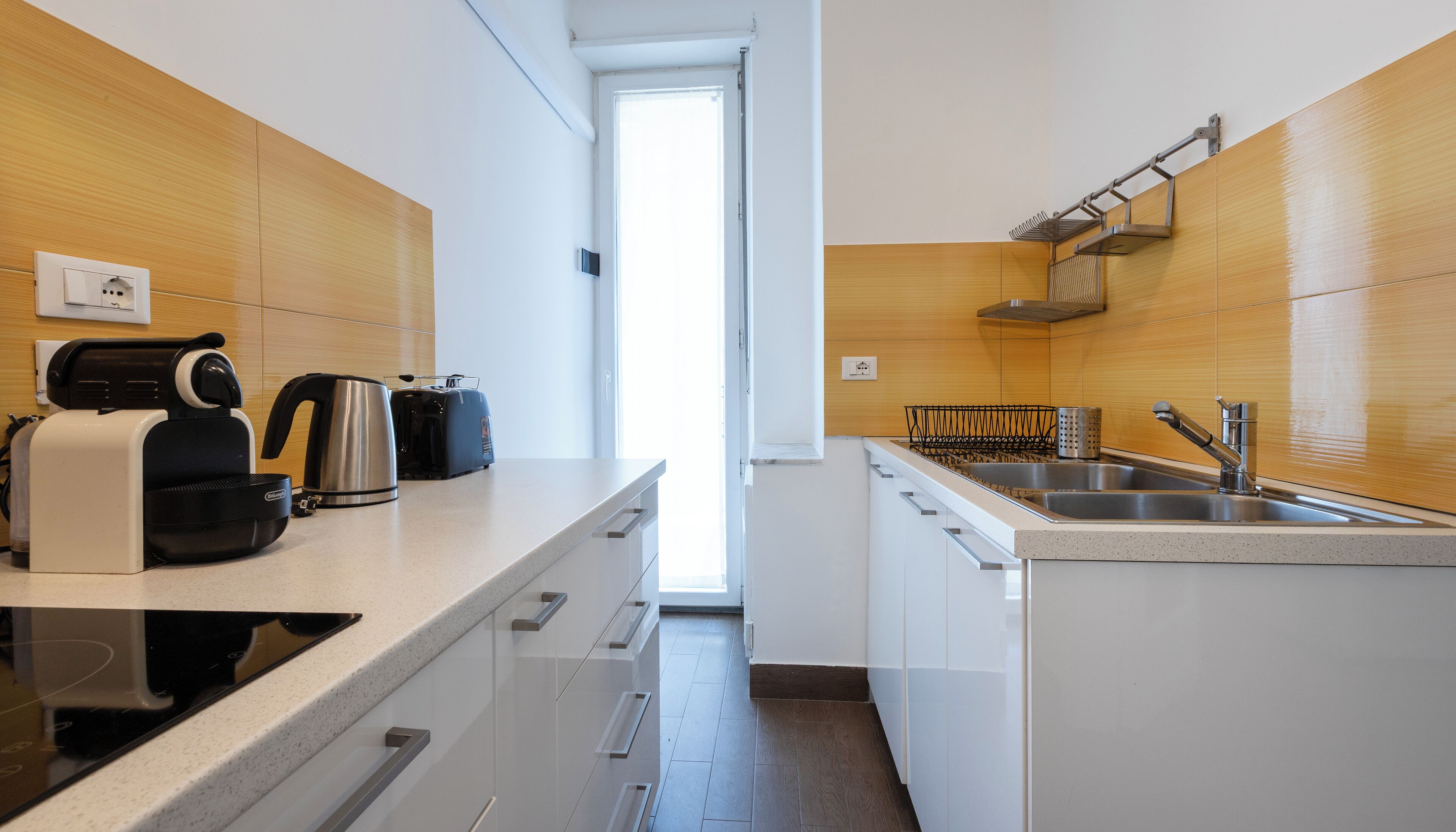 Una cocina moderna con encimera, hervidor, tostadora y lavabo.