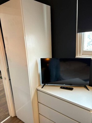 A television on a white cabinet with a remote control beside it. - #194 Smart Coventry Studio | Ideal for 2 (West Midlands)