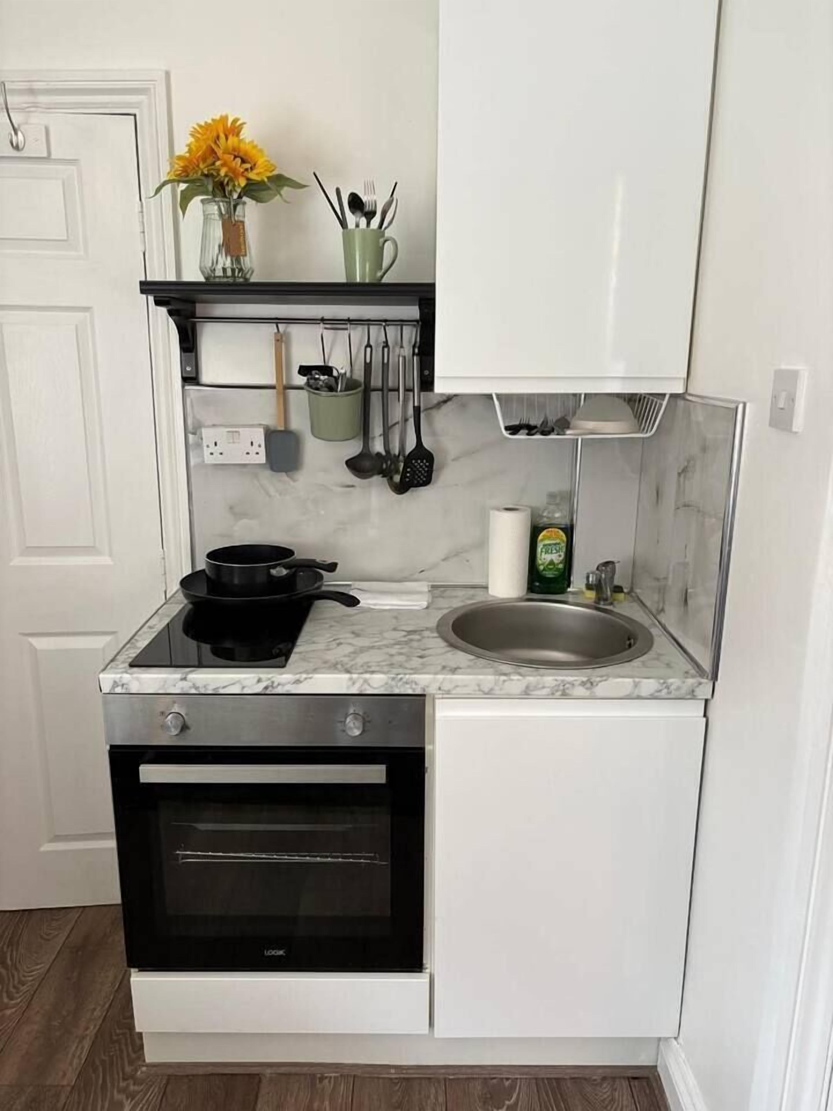 A compact kitchen with a built-in oven, a sink, and a countertop.