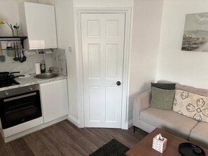A compact kitchen with a built-in oven, a sink, and a countertop. - #194 Smart Coventry Studio | Ideal for 2 (West Midlands)