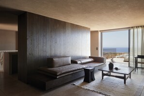 Ein modernes Wohnzimmer mit einer Couch, einem Couchtisch und Meerblick.