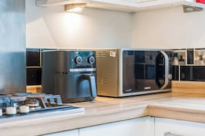 Eine Küche mit eingebautem Herd, einer Kaffeemaschine und einer Mikrowelle.