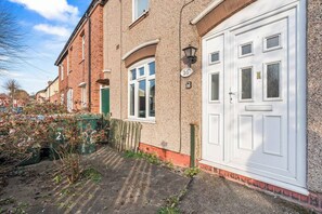 A residential property with a double garage door, a small window, and a visible house number. - #134 Cozy Retreat Close to FarGo Village -Sleeps 7 (West Midlands)