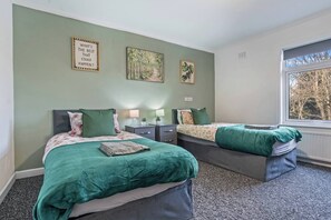 A bedroom with two beds, a window, and artwork on the walls. - #134 Cozy Retreat Close to FarGo Village -Sleeps 7 (West Midlands)