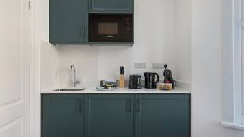 A kitchen with a microwave, sink, and cabinets.