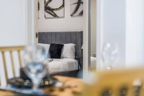 Ein Hotelzimmer mit einem Bett, einem Nachttisch und einer Wand mit abstrakter Kunst.