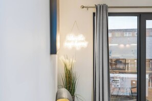 A room with a window, a wall-mounted light fixture, and a potted plant. - #178 Luxury Flat in the Heart of Birmingham-for 4 (Birmingham)