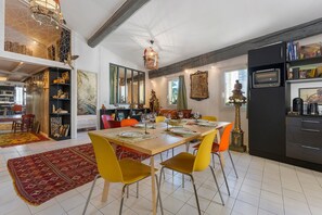 Een eethoek met een houten tafel gedekt voor vier personen, omringd door gele stoelen.
