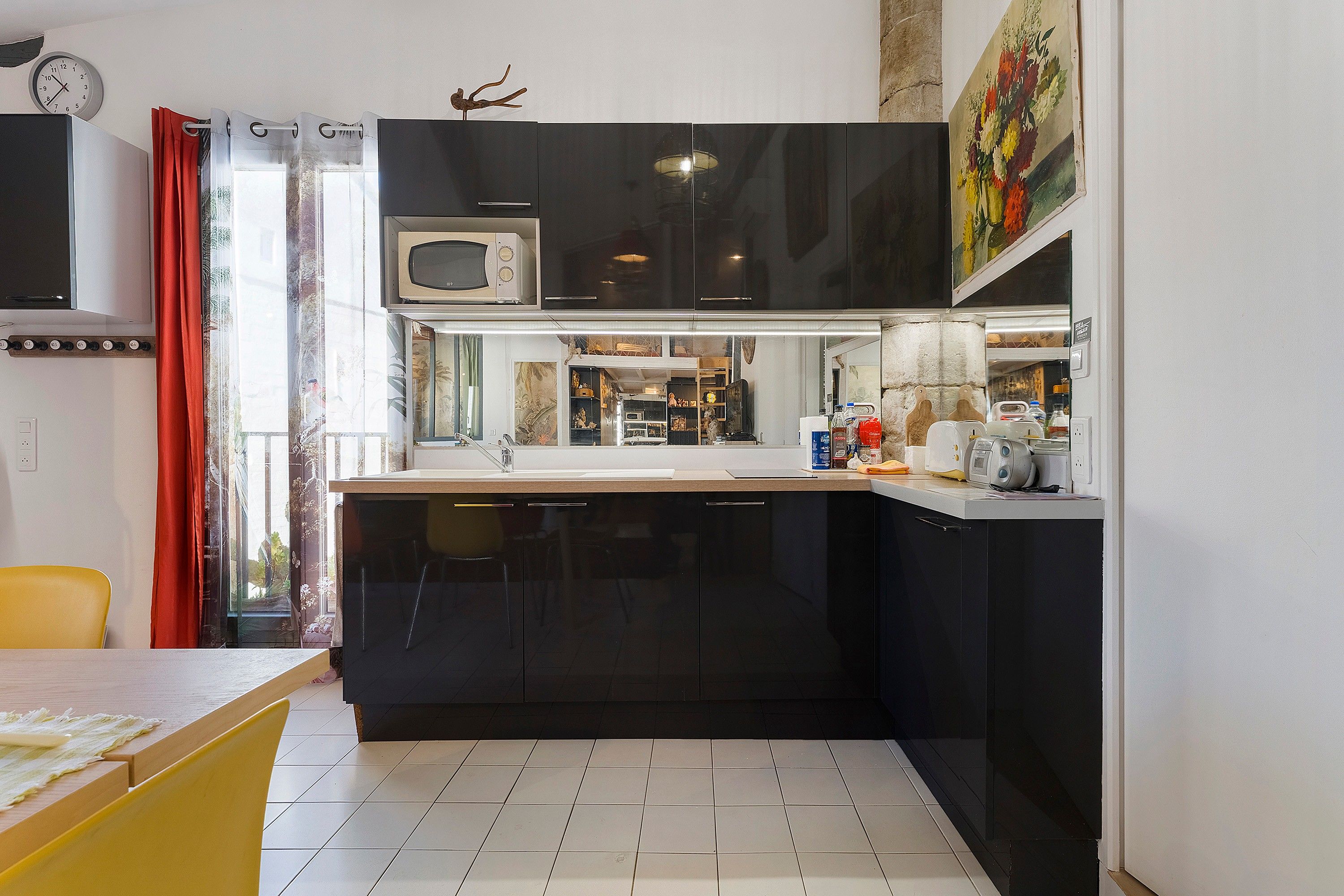 A compact kitchen with a microwave, sink, and cabinets.