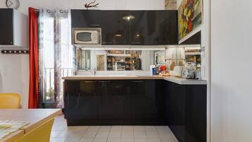A compact kitchen with a microwave, sink, and cabinets.
