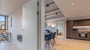 En modern inredning med matplats, kök och utsikt över staden.