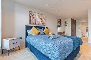 Ein modernes Schlafzimmer mit einem großen Bett, einem Nachttisch und einem Schreibtisch.