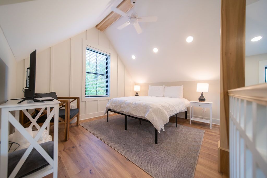 Une chambre à coucher avec un lit, des tables de chevet, un bureau et une chaise.
