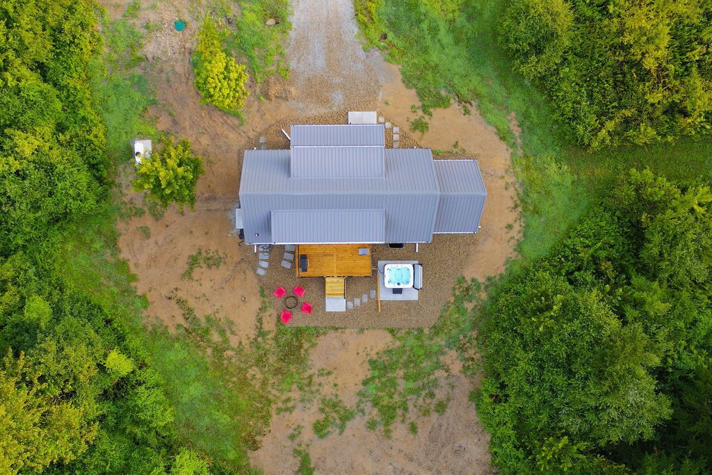 Une maison de plain-pied dotée d’une grande terrasse, entourée d’une végétation luxuriante.
