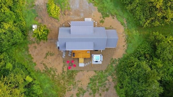 Une maison de plain-pied dotée d’une grande terrasse, entourée d’une végétation luxuriante.