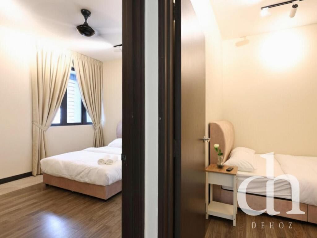 Habitación de hotel con cama, mesita de noche con lámpara y ventana con cortinas.