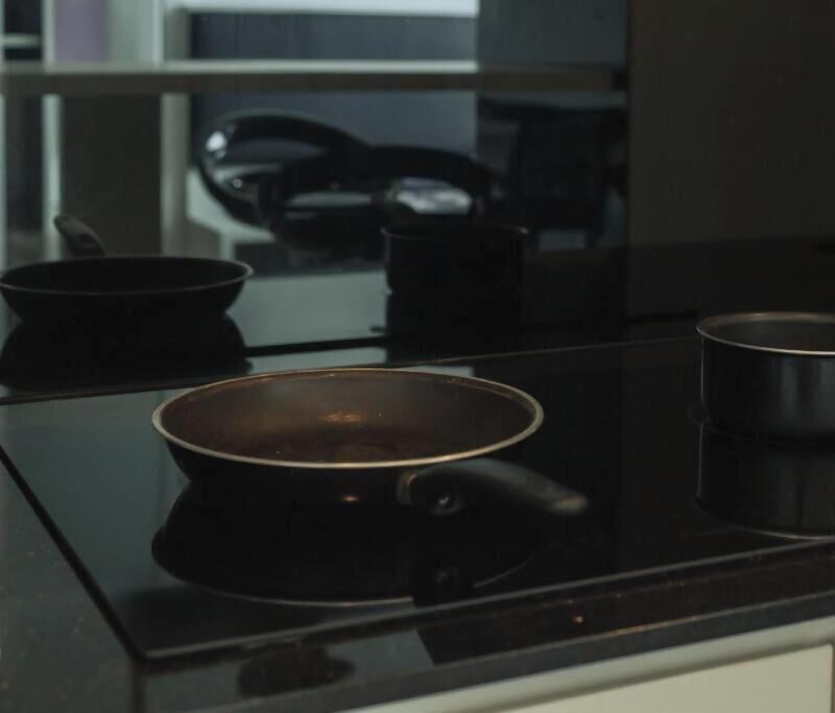 Uma cozinha com fogão, panela e caldeirão.