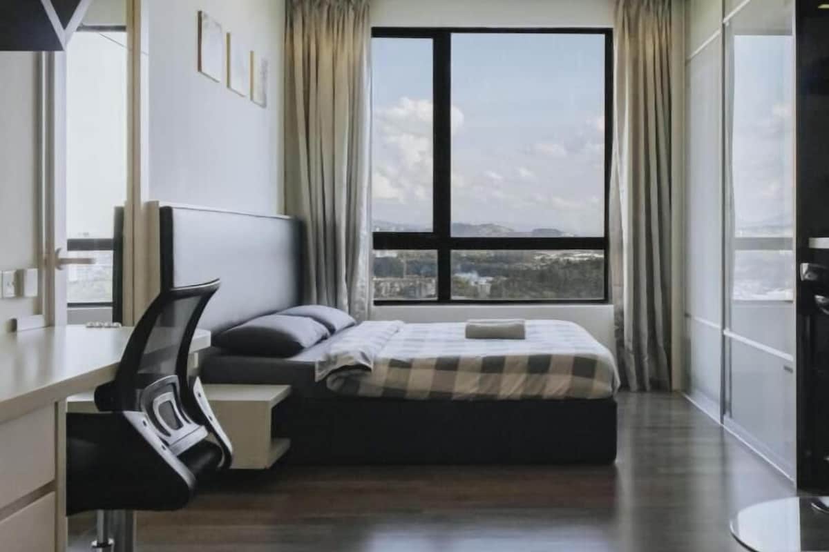 Une chambre d’hôtel moderne avec une grande fenêtre, un lit, un bureau et une chaise.
