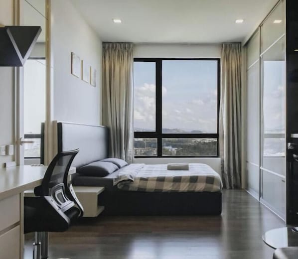 Une chambre d’hôtel moderne avec une grande fenêtre, un lit, un bureau et une chaise.
