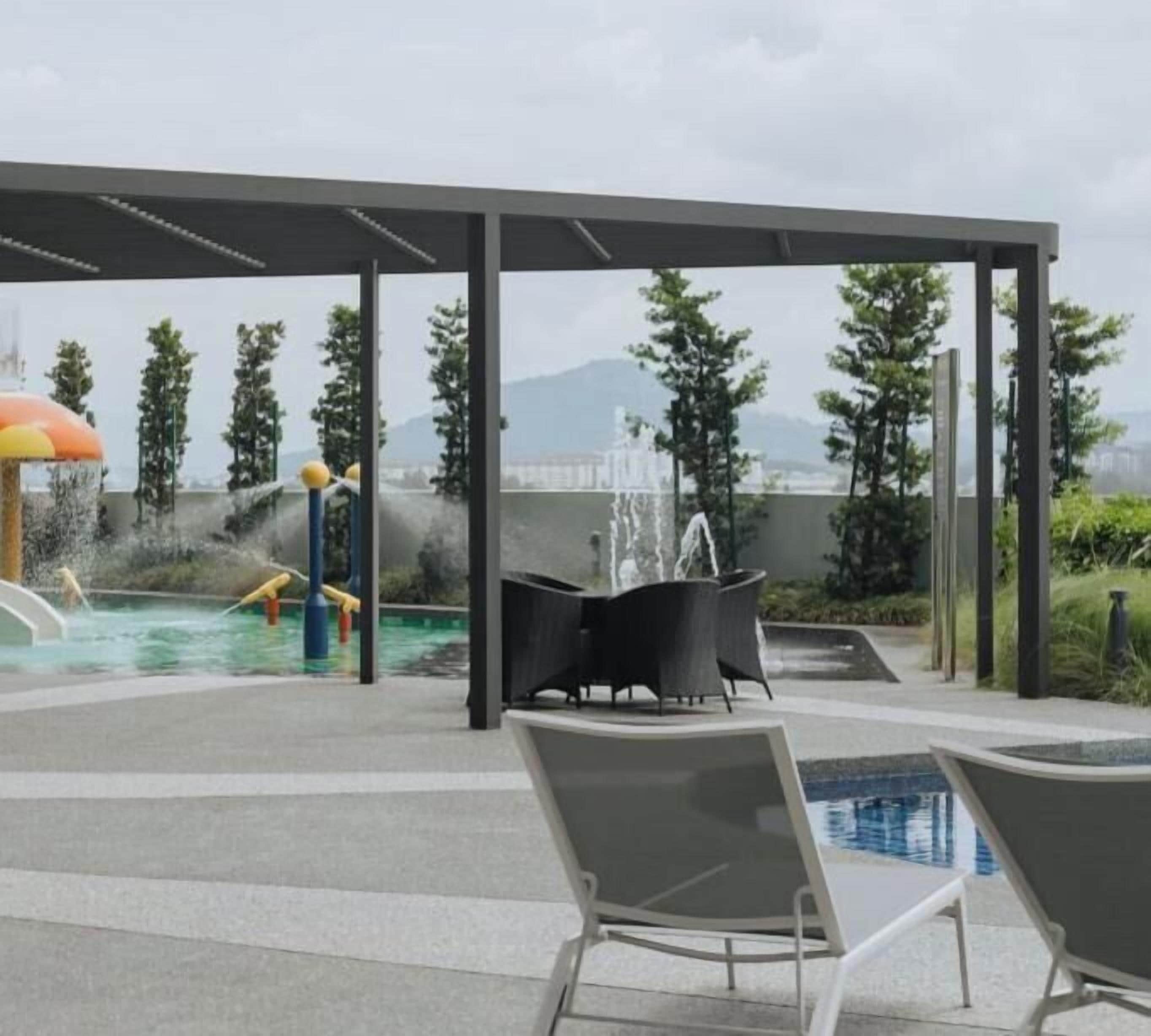 A rooftop pool area with lounge chairs, a water feature, and a covered seating area.