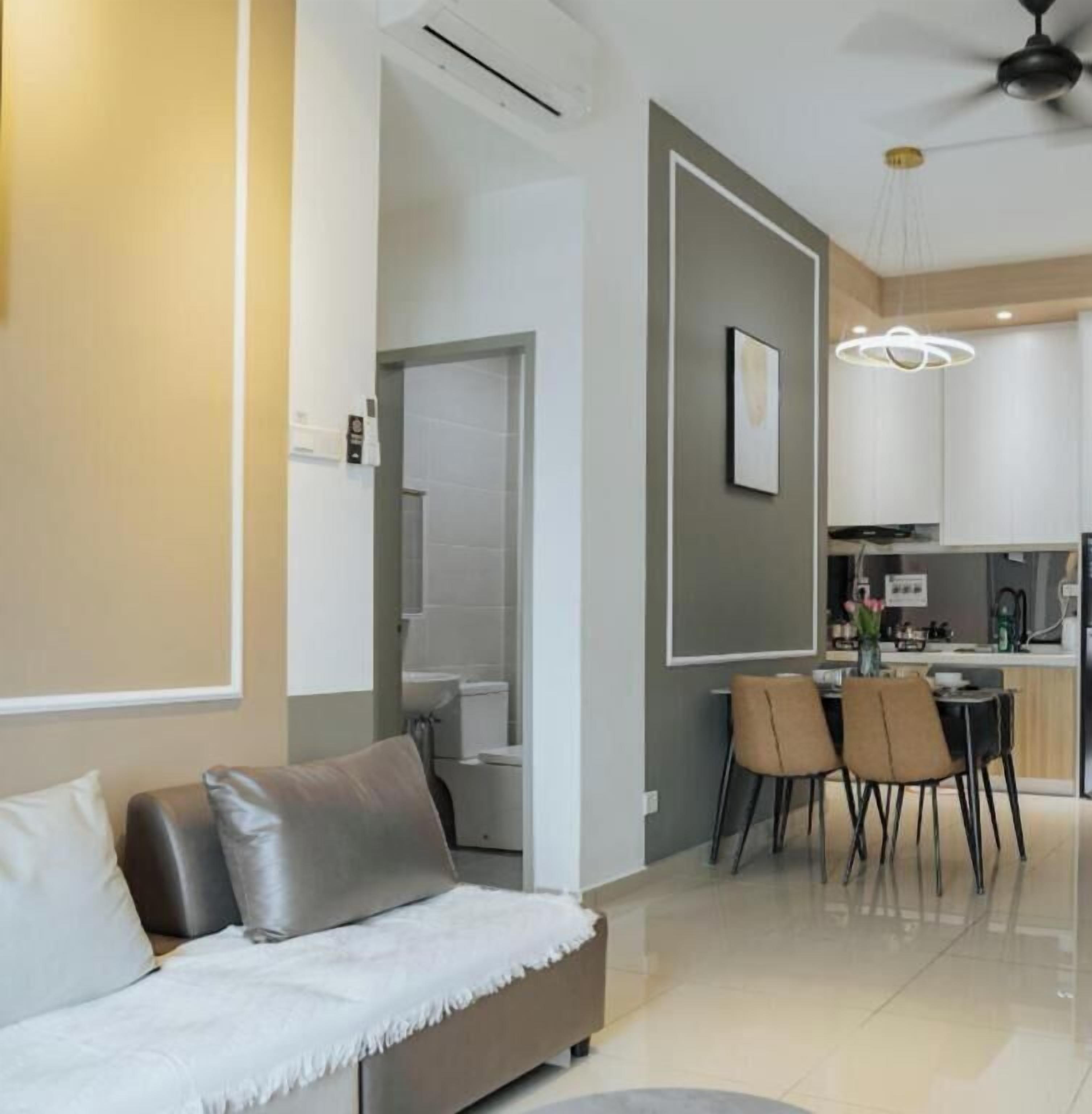 Una sala de estar moderna con un sofá, un comedor con sillas y una cocina al fondo.