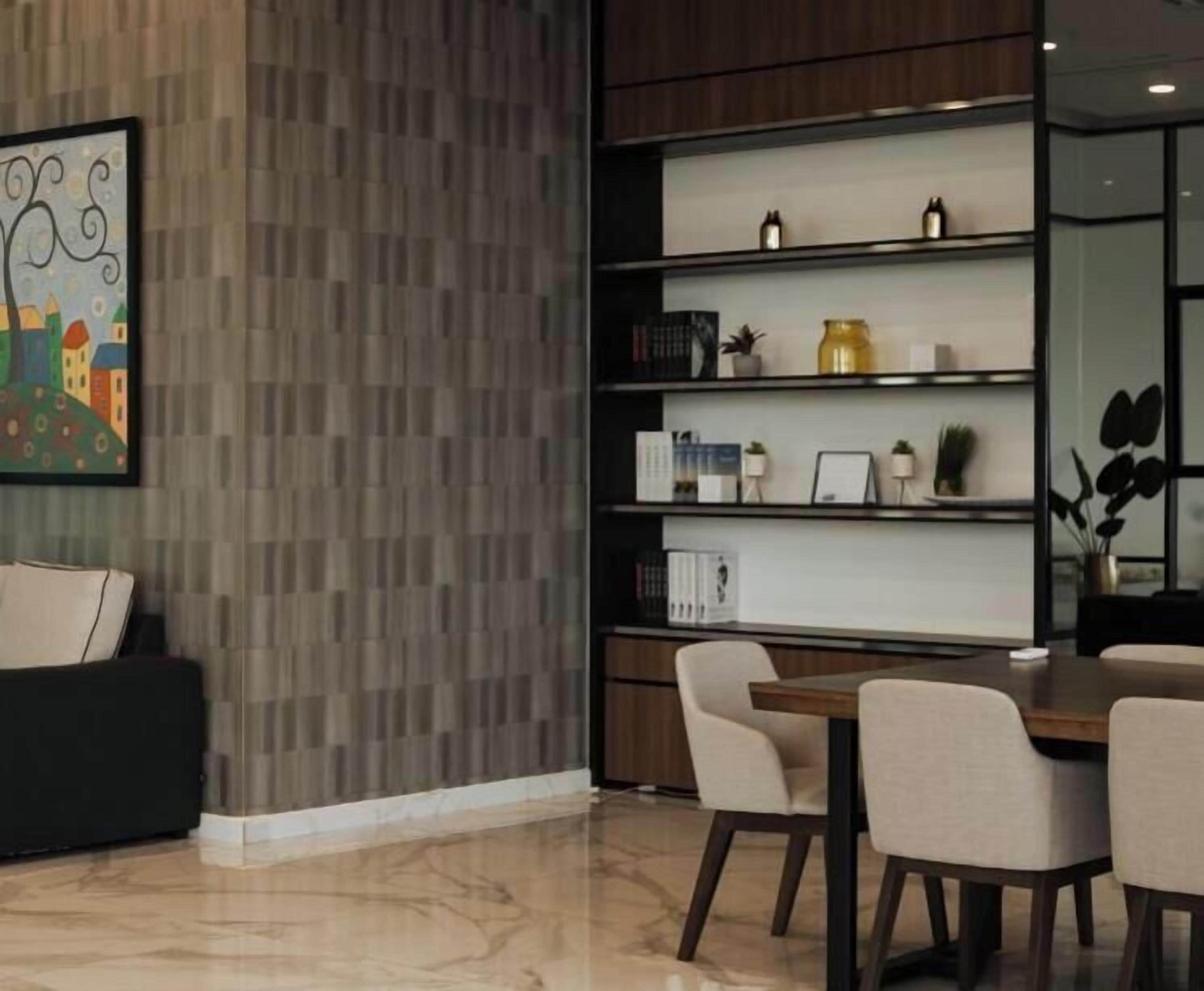 A modern interior with a dining area, a bookshelf, and a decorative wall panel.