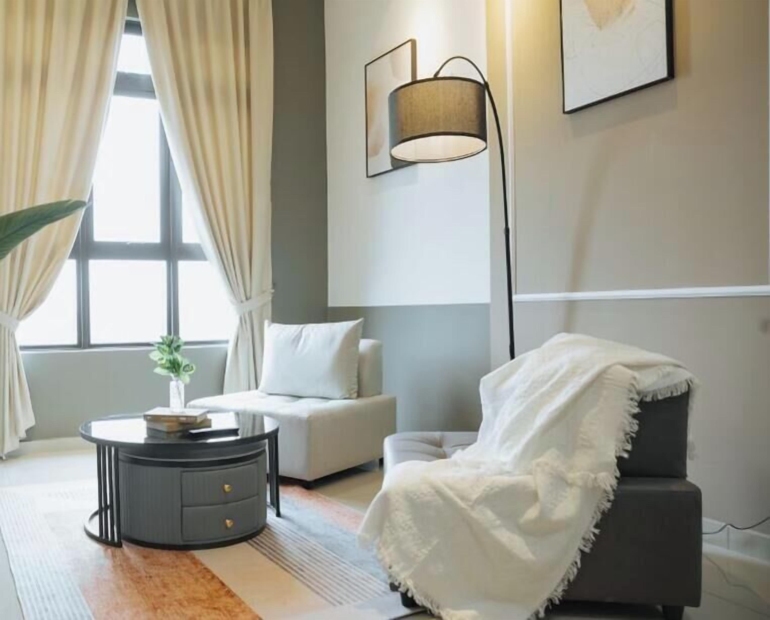 A modern living room with a sofa, a round coffee table, and a floor lamp.