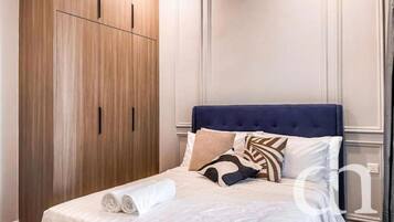 Habitación de hotel con cama, armario y una pared con paneles.
