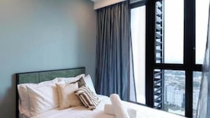 A hotel room with a bed, curtains, and a window with a view of buildings. - Bloomsvale Residence OKR By Dehoz Suites (Kuala Lumpur)
