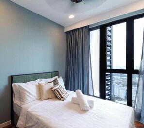 A hotel room with a bed, curtains, and a window with a view of buildings. - Bloomsvale Residence OKR By Dehoz Suites (Kuala Lumpur)