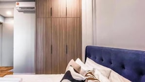 A bedroom with a bed, a wardrobe, and an air conditioning unit. - Bloomsvale Residence OKR By Dehoz Suites (Kuala Lumpur)