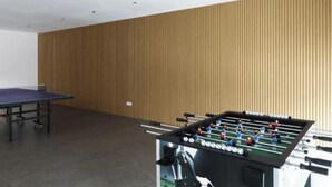 Quarto com mesa de futebol de mesa e mesa de pingue-pongue.