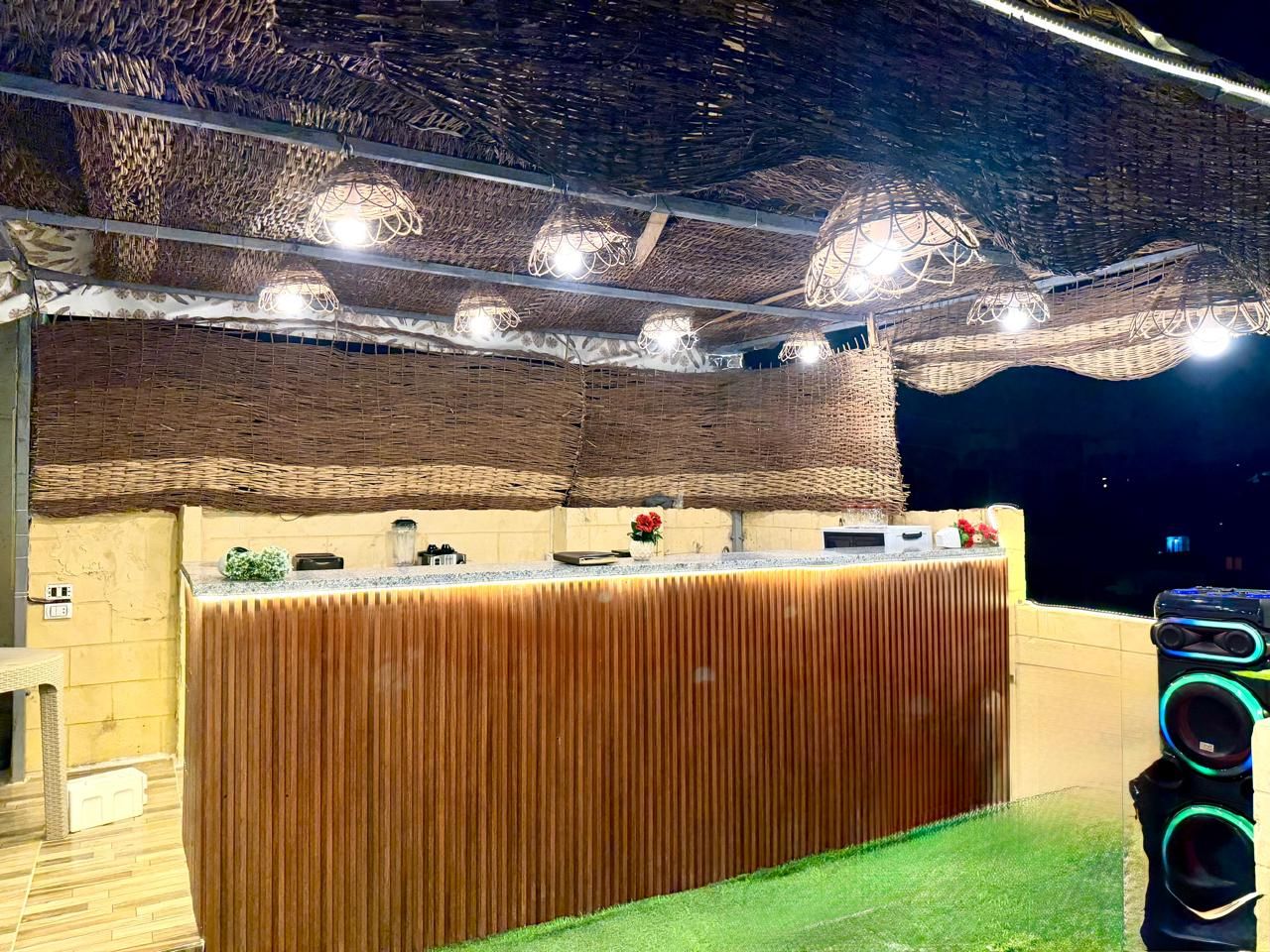 A reception area with a wooden counter, decorative lighting, and a speaker system.