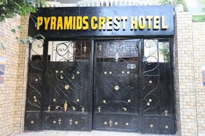 A black wrought iron gate with the inscription 'PYRAMIDS CREST HOTEL' in gold letters. - pyramids crest hotel (Giza)