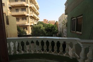 A balcony with a balustrade overlooking a residential area with multi-story buildings and greenery. - pyramids crest hotel (Giza)
