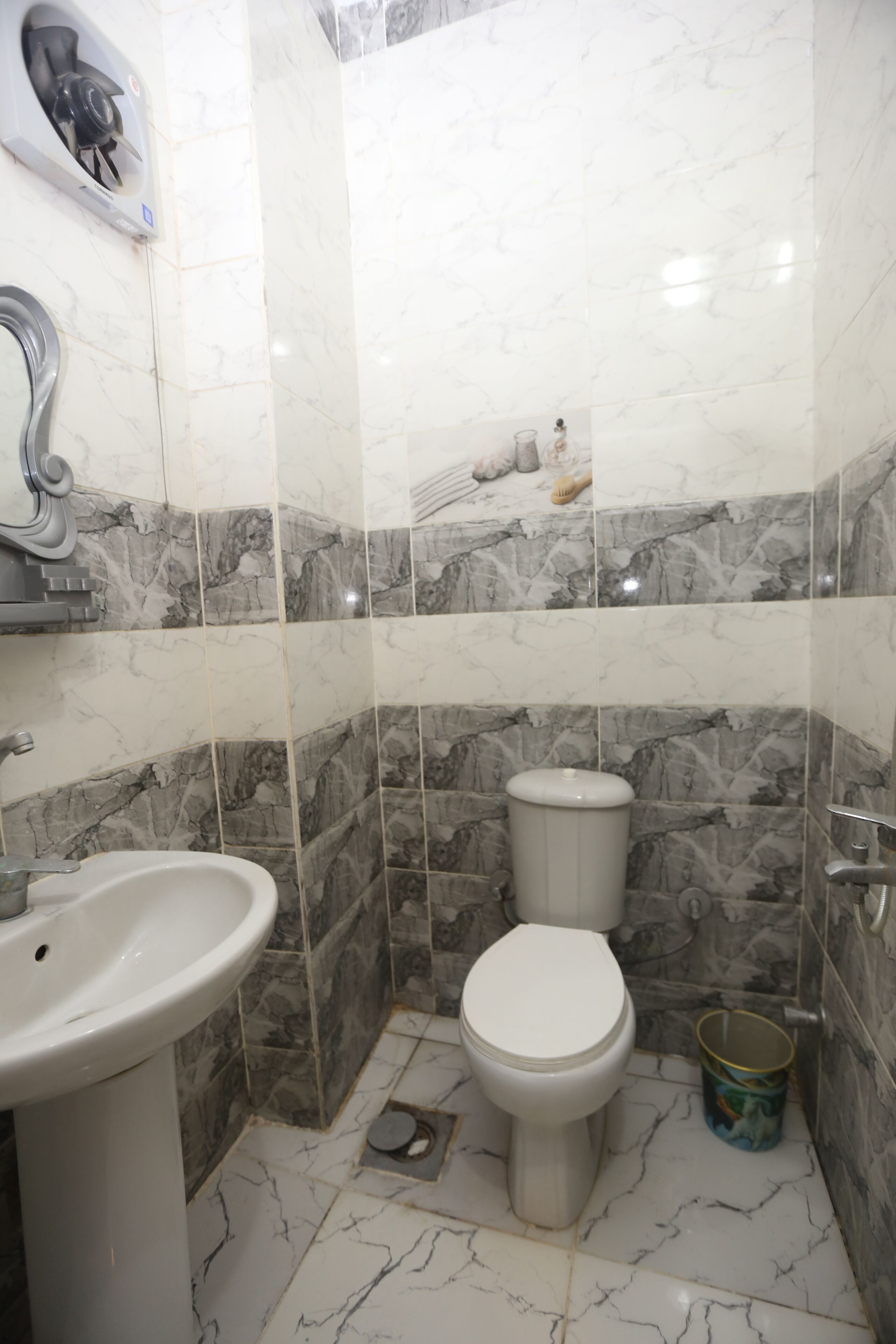 A bathroom with a toilet, sink, and shower area.