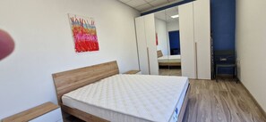 Ein Schlafzimmer mit Bett, Nachttisch, Kleiderschrank und Spiegel.