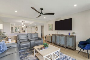 Un salon moderne avec un canapé, une table basse et un téléviseur.
