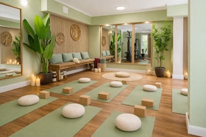 A yoga studio with wooden floors, green mats, and a wooden bench with cushions. - Villa Manatee - Wellness Apartment with a Balcony (Sellin)