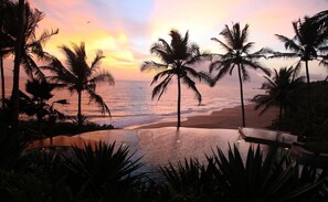 A beach scene with palm trees and a pool. - Niraamaya Retreats Surya Samudra Kovalam (Neyyattinkara)