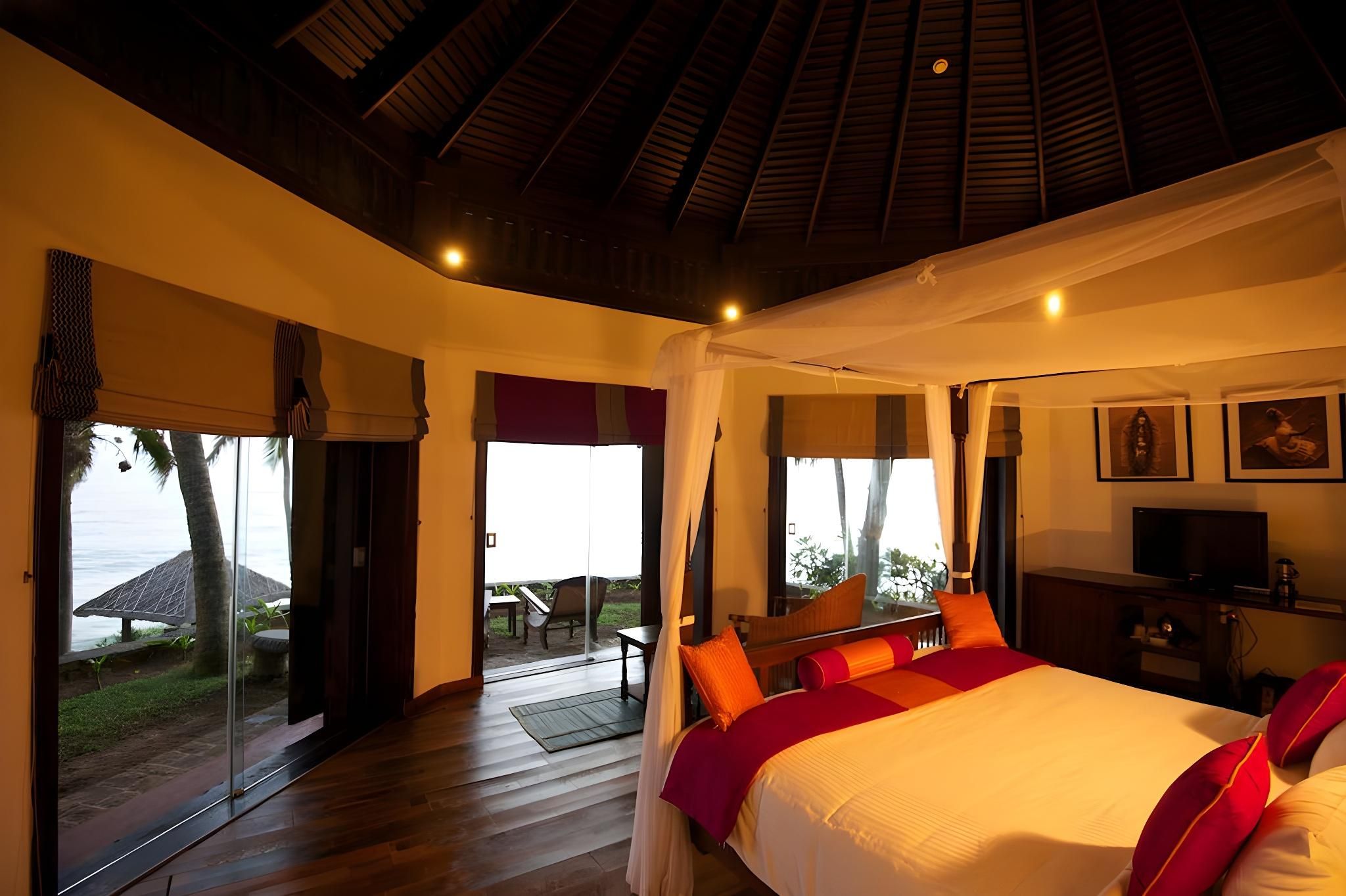 A bedroom with a large bed, a television, and a view of the outdoors.