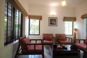 A room with a sofa set, a coffee table, and a framed picture on the wall. - Niraamaya Retreats Surya Samudra Kovalam (Neyyattinkara)