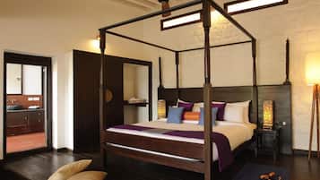 A four-poster bed with a wooden frame, a headboard, and a bedside table with a lamp.
